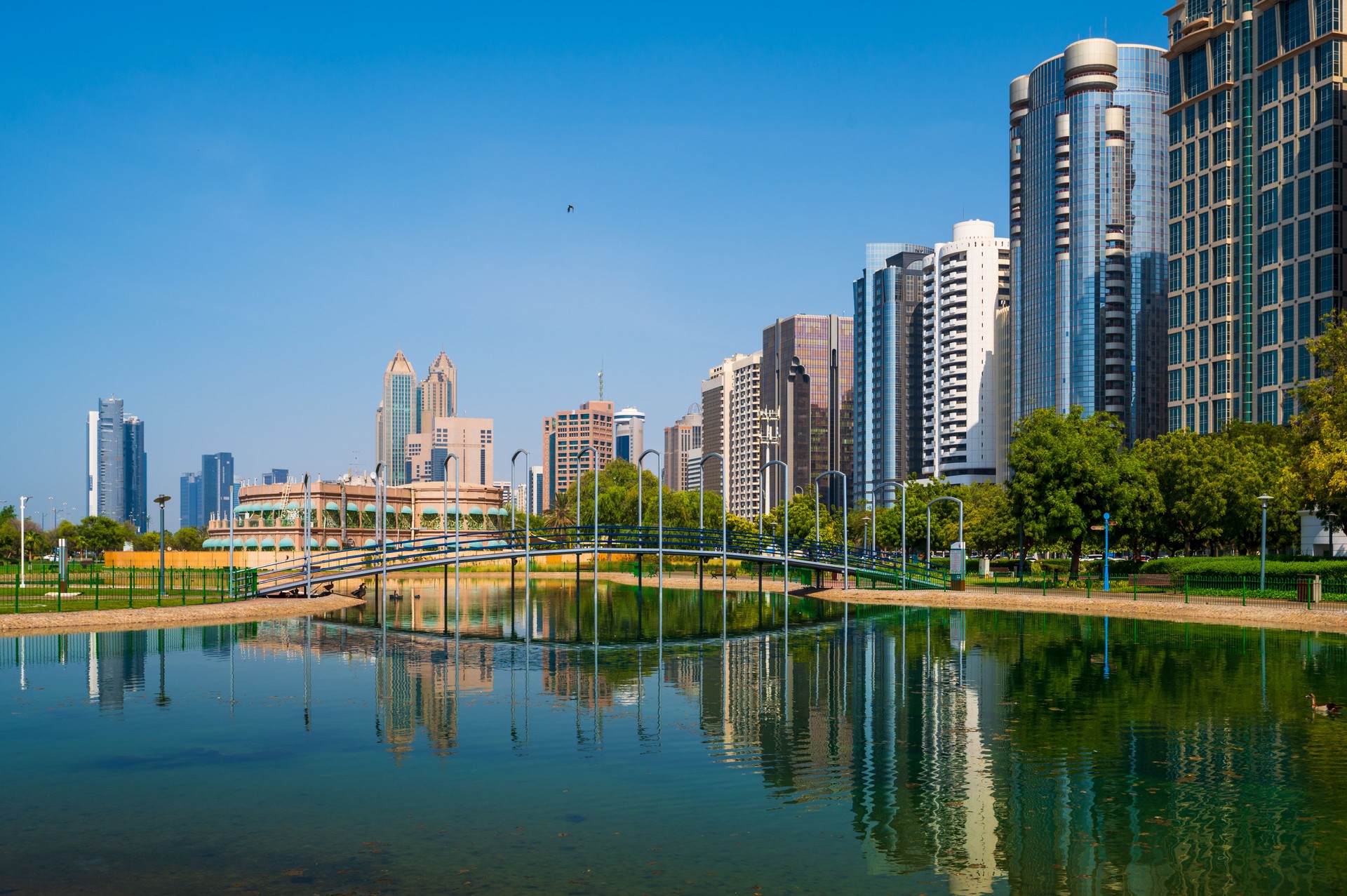 Abu Dhabi lake park with downtown skyline reflected in the water at the UAE capital city